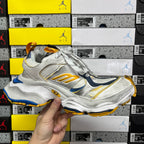 Balenciaga unisex sneaker at angle with silver upper, blue accents, gold sole