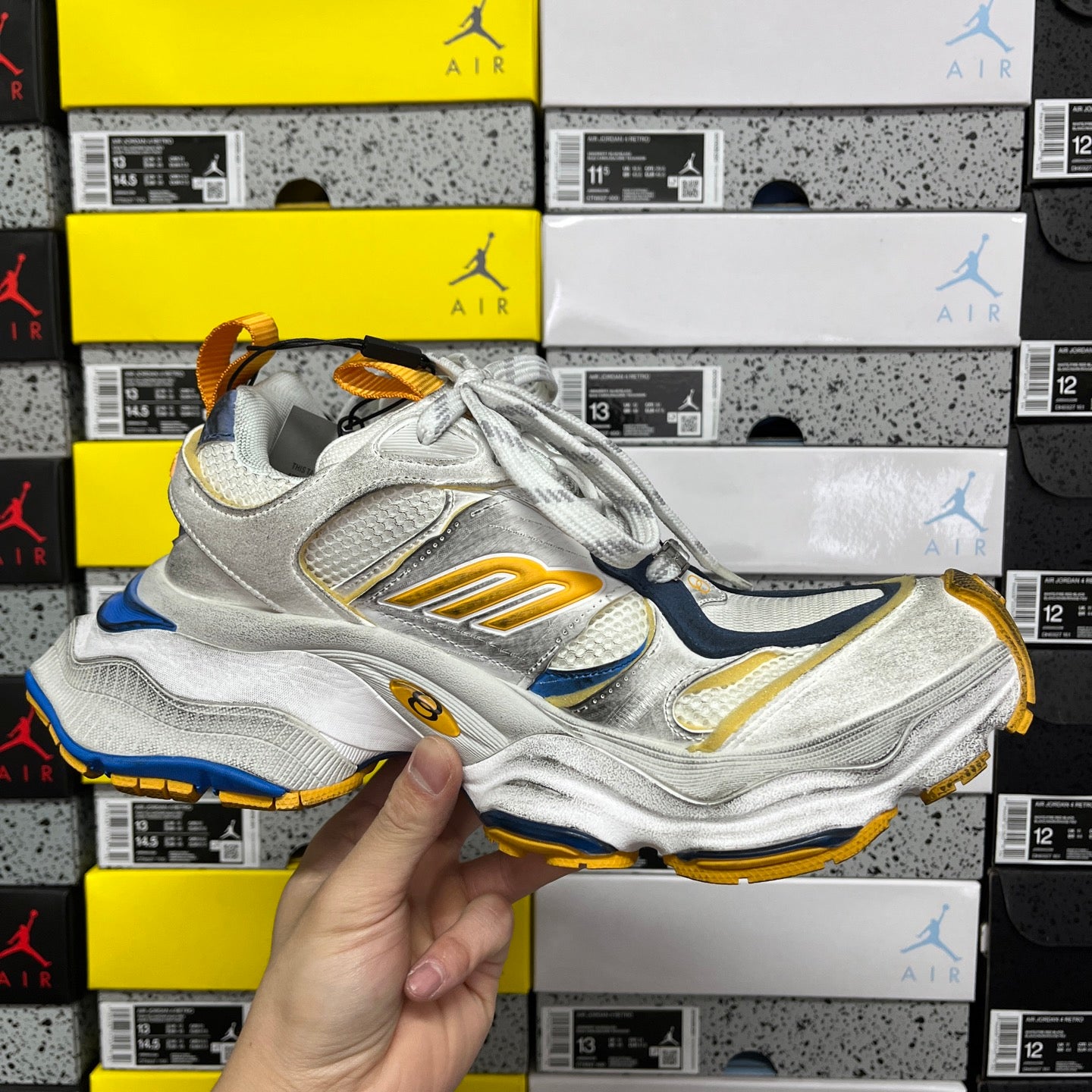 Balenciaga unisex sneaker at angle with silver upper, blue accents, gold sole
