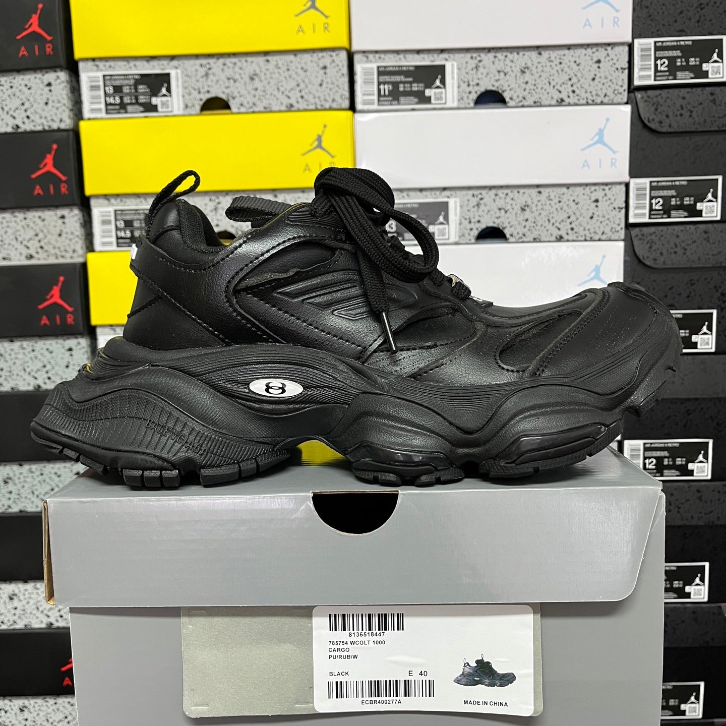 Black lace-up sneakers with sculpted overlays, padded collar, and thick rubber outsole