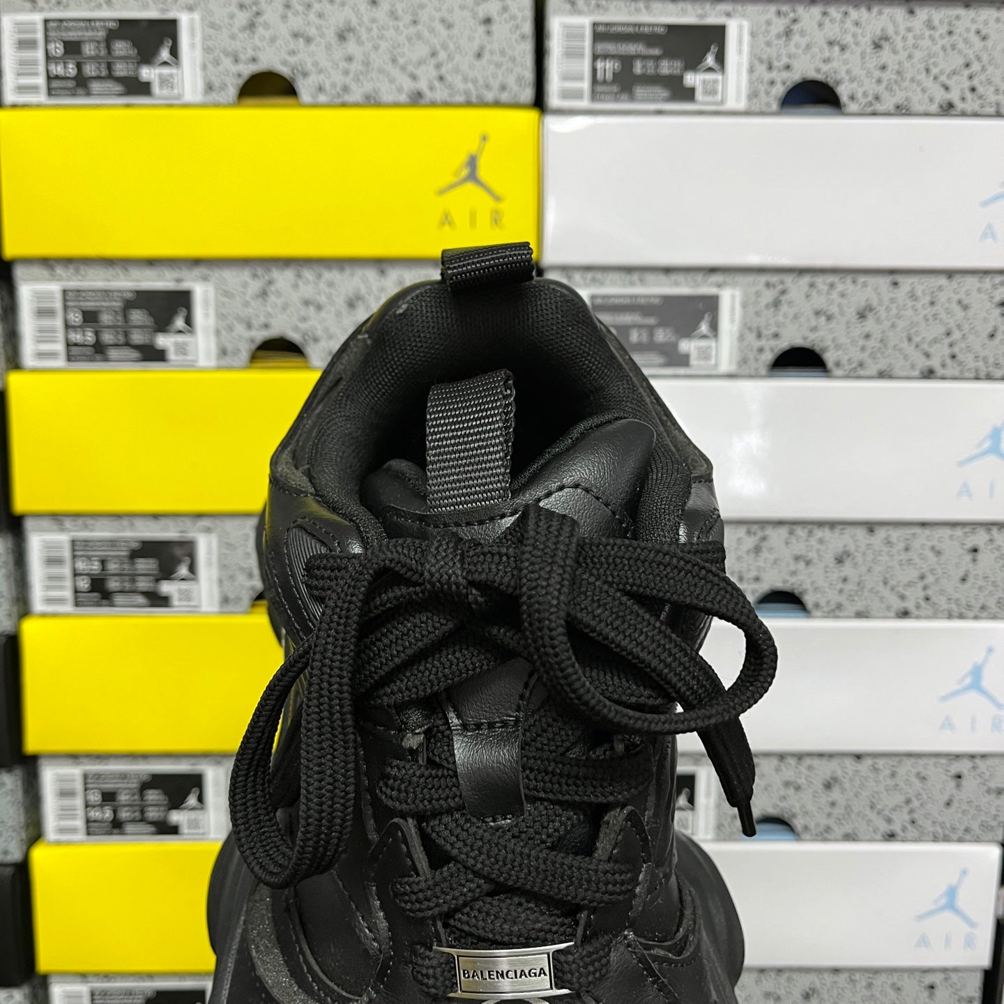 Black sneakers tongue and laces with fabric label patch near the ankle