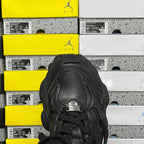 Black sneakers front view with lace-up eyelets and padded tongue label detail