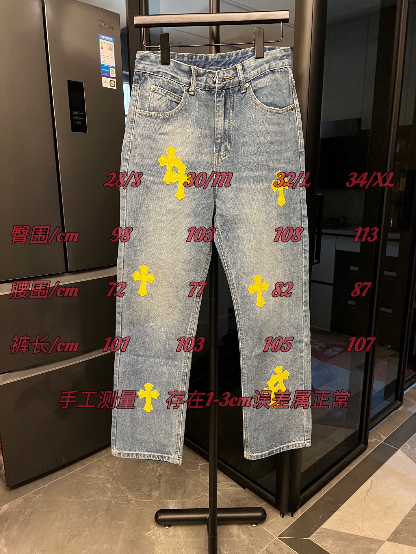 Light-wash denim pants with yellow cross patches, full front view