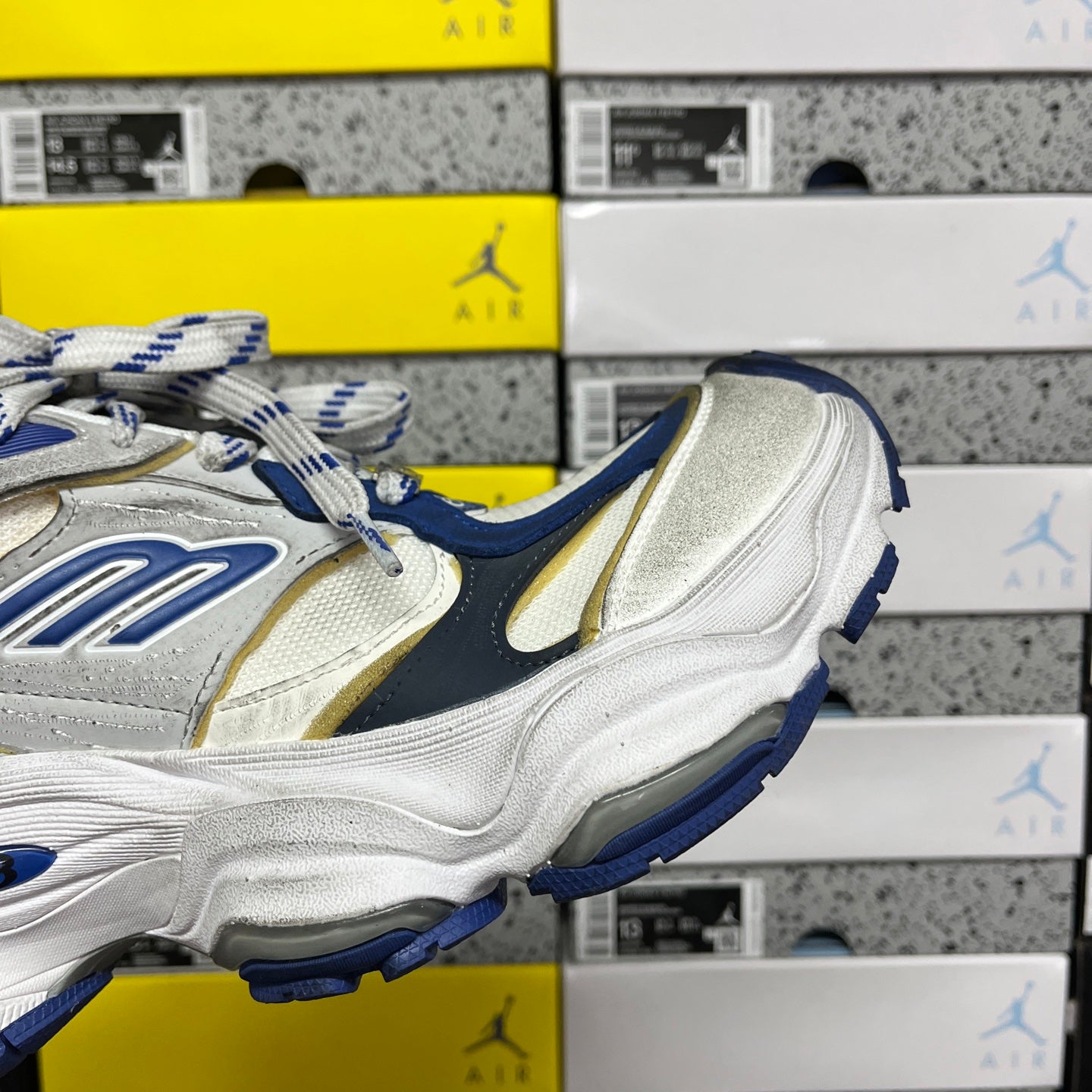White and blue lace-up sneakers with gold accent panel and ridged sole