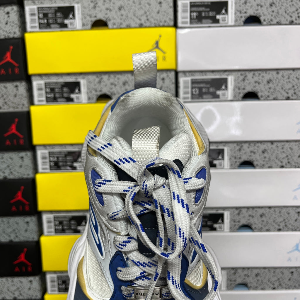White and blue lace-up sneakers with gold heel detail and textured upper