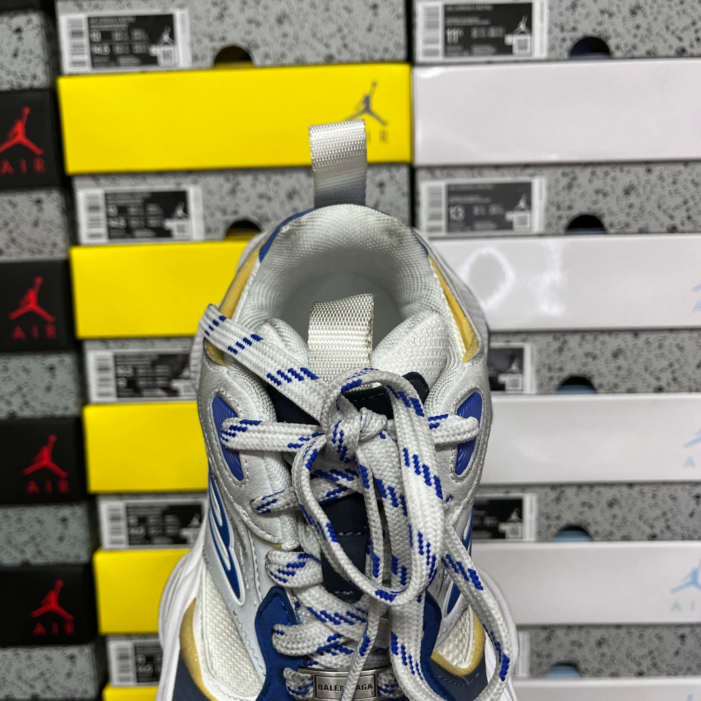 White and blue lace-up sneakers with gold heel detail and textured upper