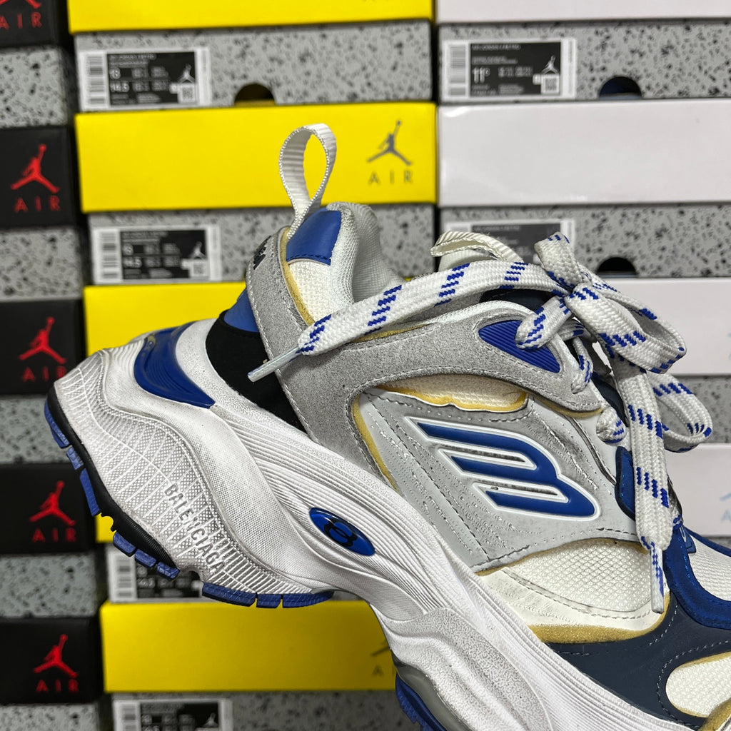 White, blue and gold sneakers with striped laces and elevated tongue