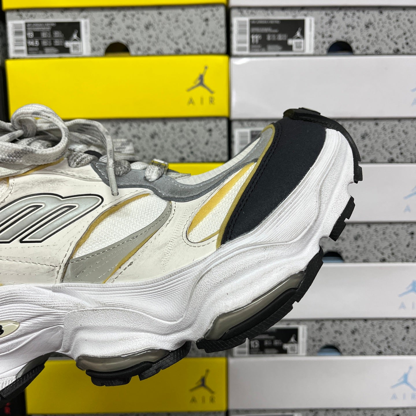 Balenciaga unisex sneakers, angled side view in white and gray with yellow stripe and black sole