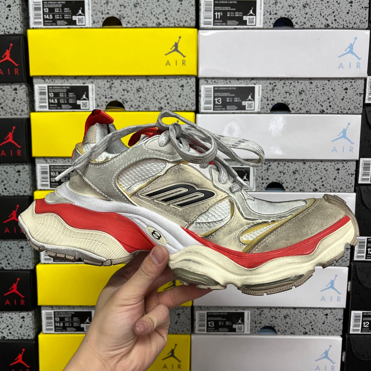 Balenciaga Air sneaker side view, metallic silver upper with red and beige accents