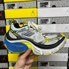 Front view of silver and gray lace-up sneaker with blue and neon yellow-green accents