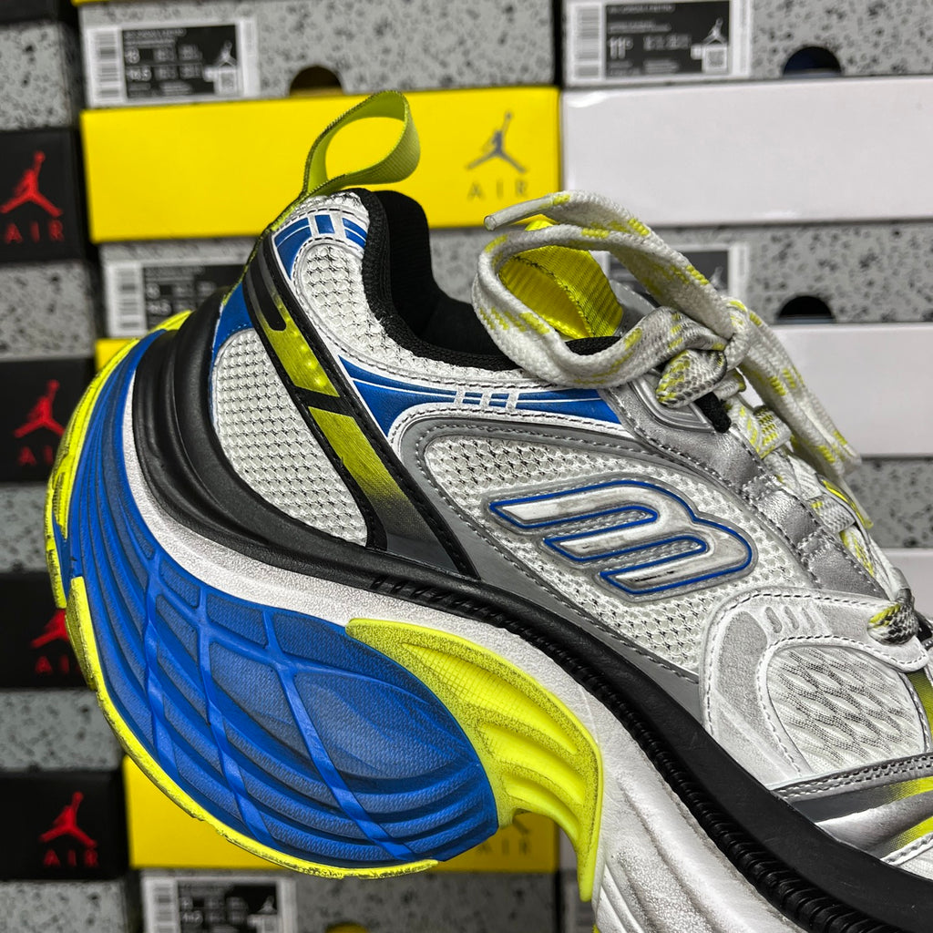 Front-quarter view of silver sneaker with blue side panel, neon yellow-green accents