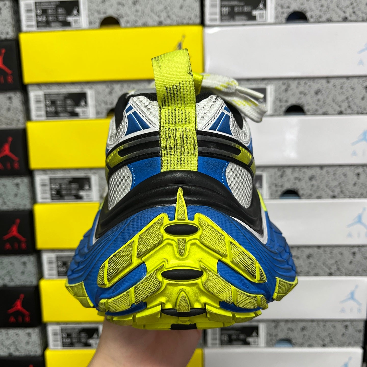 Bottom tread view of sneaker with bright neon green and blue rubber outsole