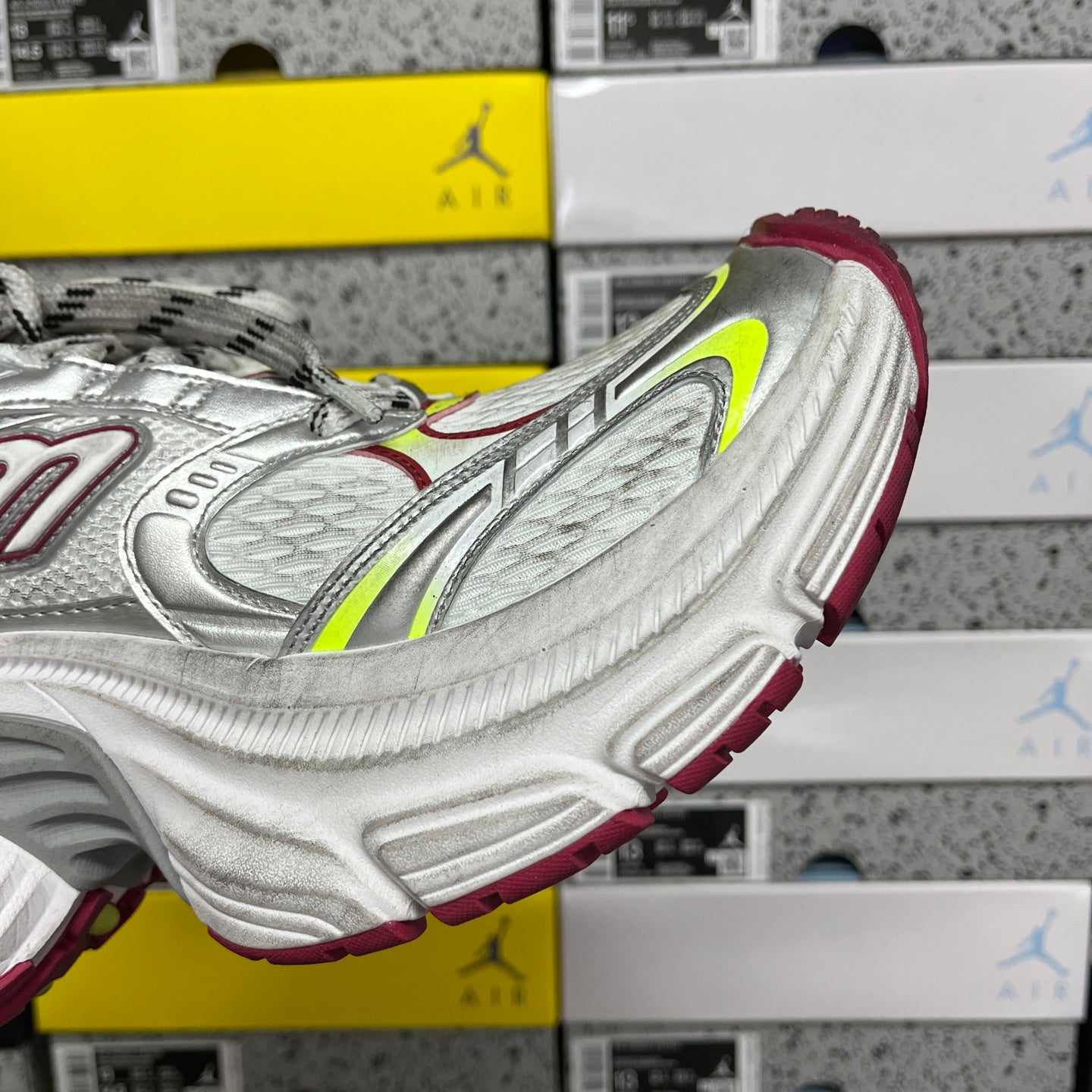 Silver sneaker side with neon green swoosh detail and burgundy heel trim