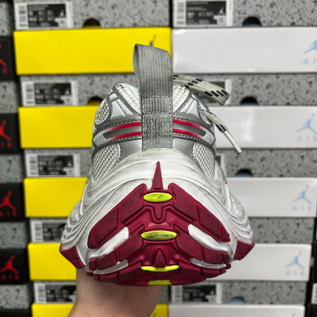 Silver sneaker outsole with burgundy traction pods and neon green highlights