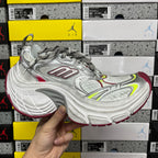 Silver sneaker with red and neon green paneling, lace-up front and cushioned sole