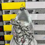 Silver sneaker with lace-up closure and rounded heel collar, textured upper