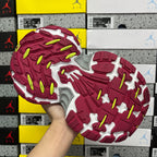Silver and burgundy sneaker outsole with red traction pattern and neon green accents