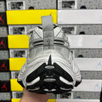 Silver running shoe with dark rubber outsole tread and heel traction pattern