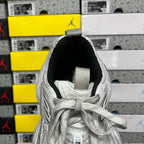 Silver lace-up running shoe with black sock lining and fabric heel strap