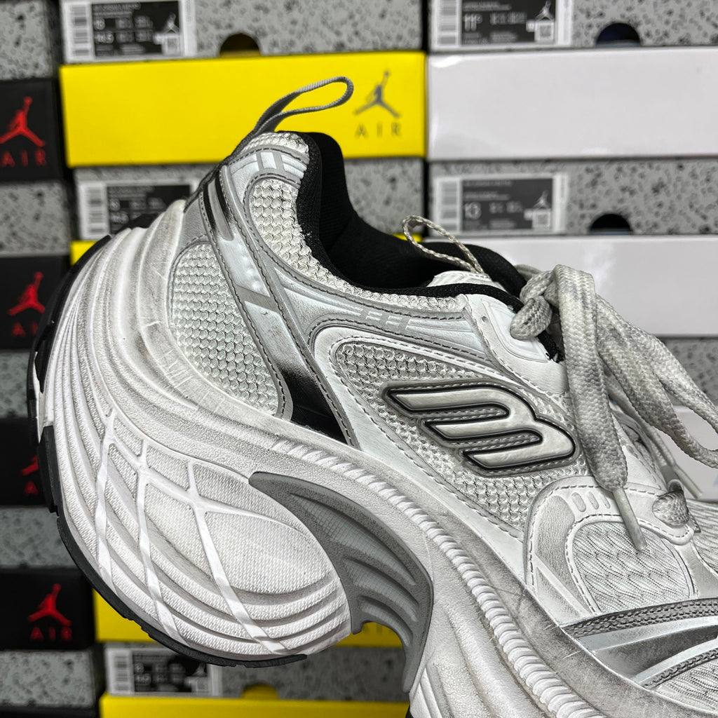 Silver unisex running shoe with mesh side panels, lace-up, and black inner lining