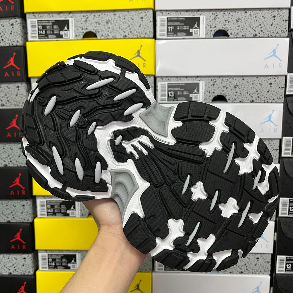 Silver and black outsole view of a lace-up running shoe with deep traction