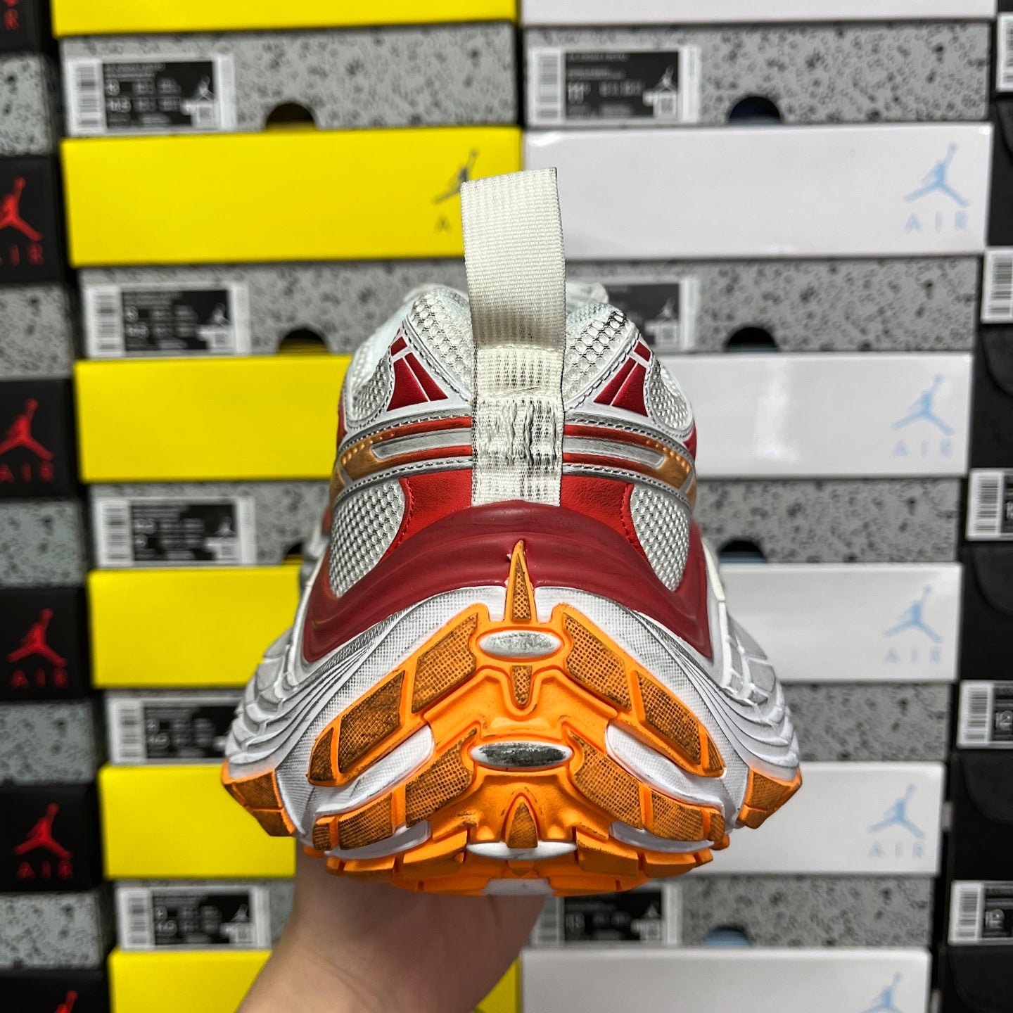 Balenciaga running shoe outsole view, orange tread with white sections