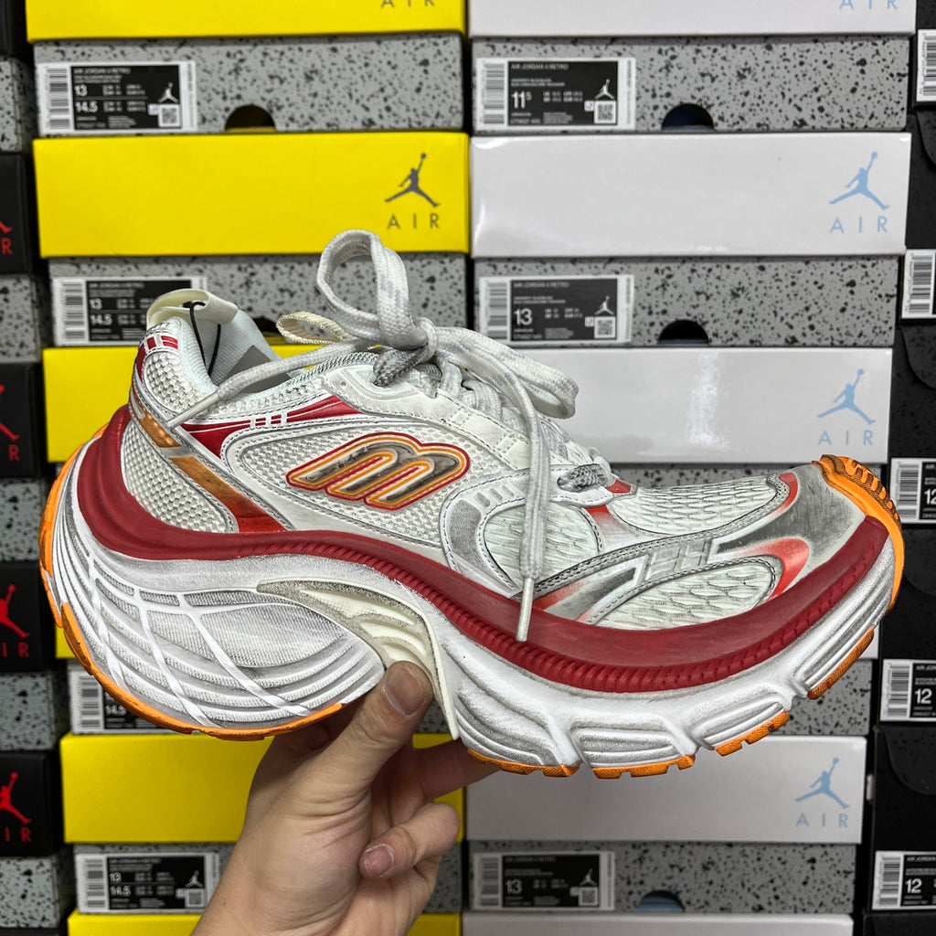 Balenciaga running shoe front view, white/silver upper with red trim and orange outsole