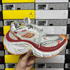Balenciaga running shoe front view, white/silver upper with red trim and orange outsole