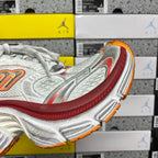 Balenciaga running shoe side profile, white upper with red band and orange sole edge