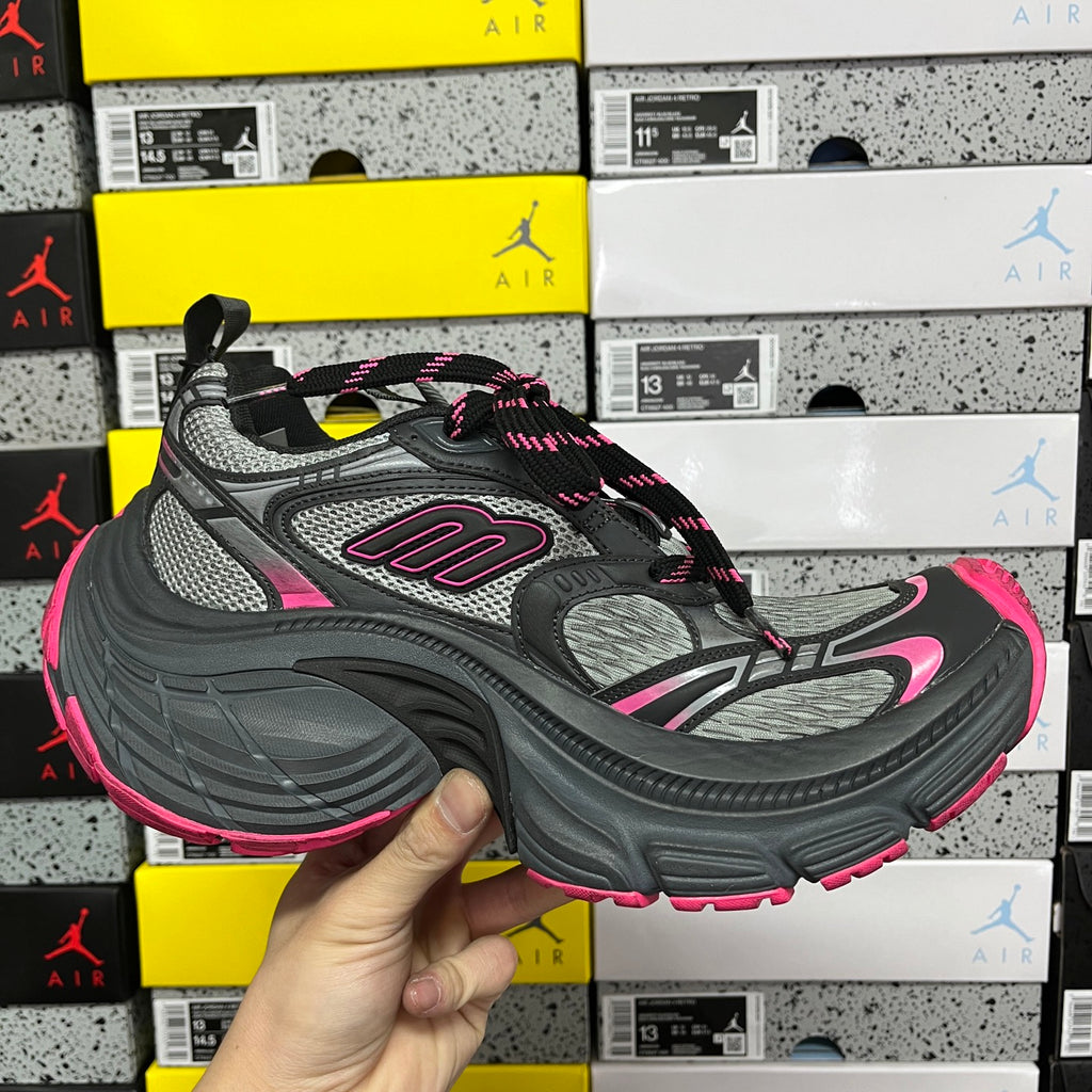 Three-quarter view of black and gray running shoes with pink accents and lace-up top.