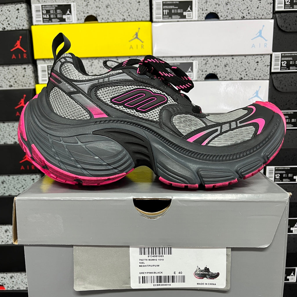 Gray and black running shoe with pink trim, chunky sole, and lace-up design.