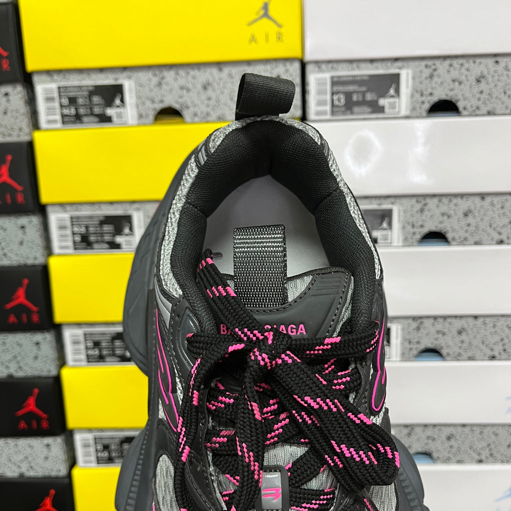 Rear view of black running shoe with pink shoelaces and padded heel collar.