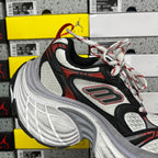 Black and white chunky running sneaker with red logo accents and red-and-white laces