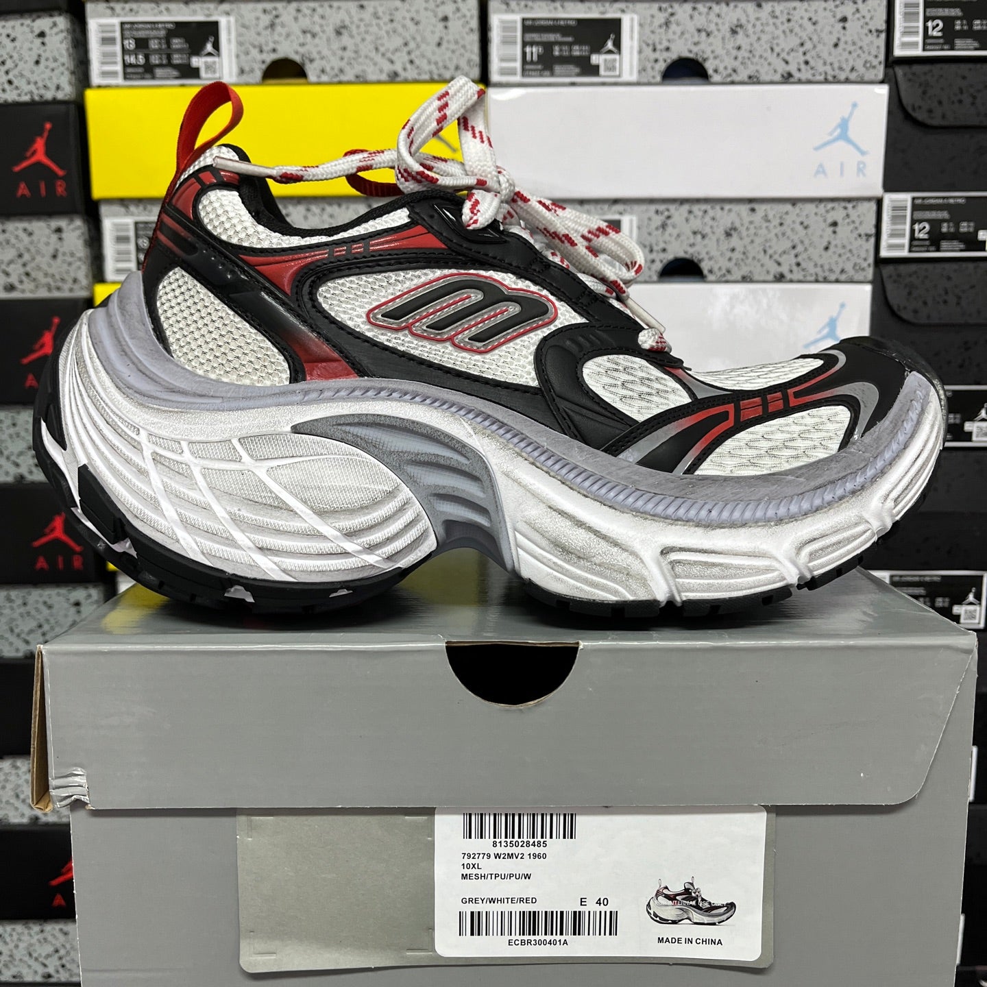 Black and gray chunky running sneaker with red trim, lace-up upper and visible sole
