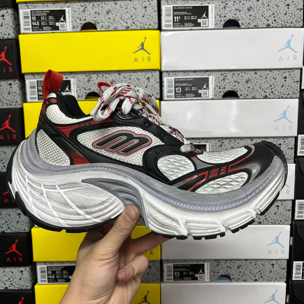 Black and white chunky running sneaker with red trim, lace-up closure and thick sole