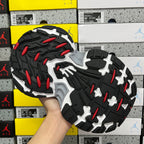 Chunky rubber outsole with red traction pods and black tread against white midsole
