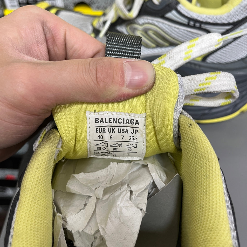 Balenciaga size label on neon yellow tongue of lace-up sneaker, with laces above.