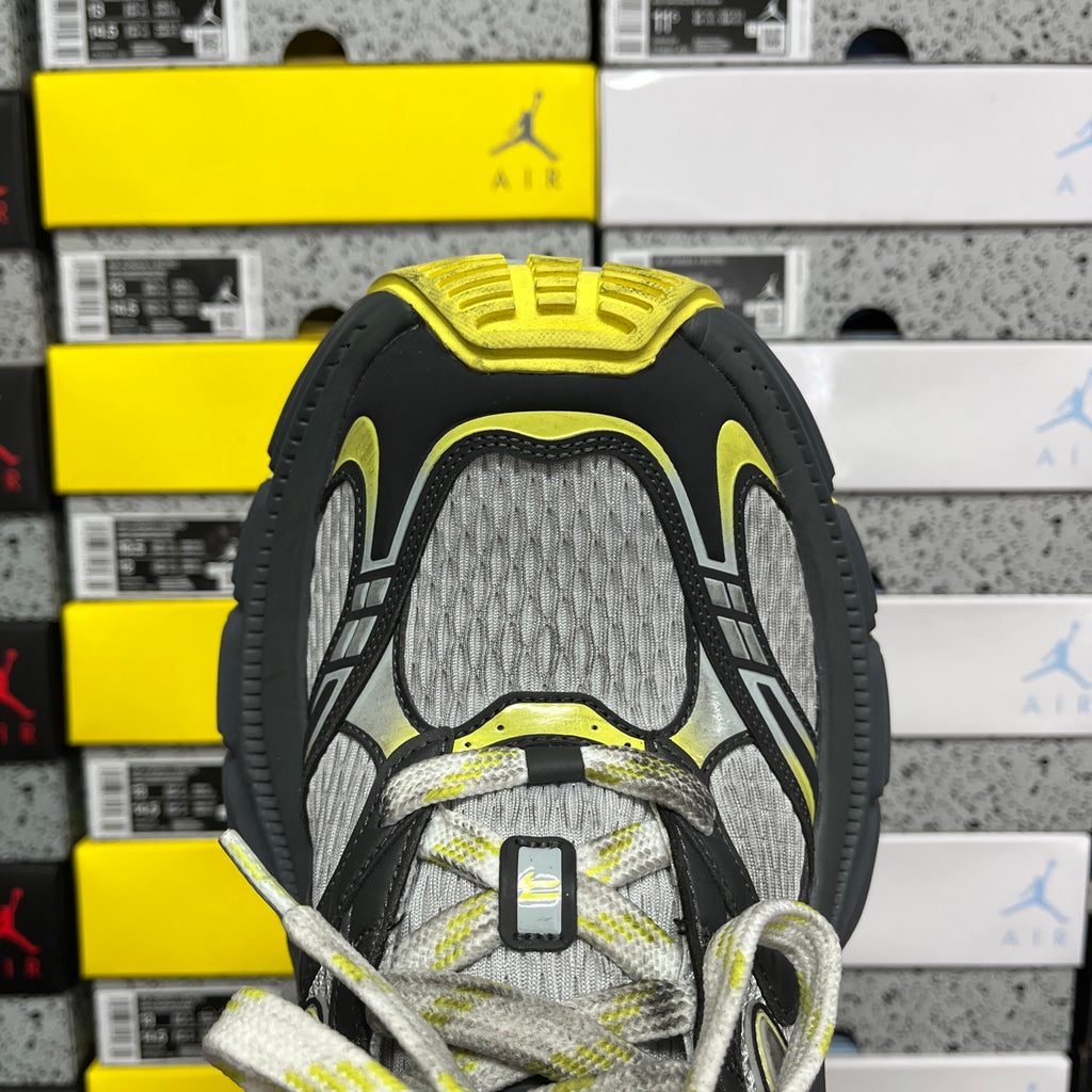 Heel-on lace-up sneaker showing inner collar lining in neon yellow and gray mesh.