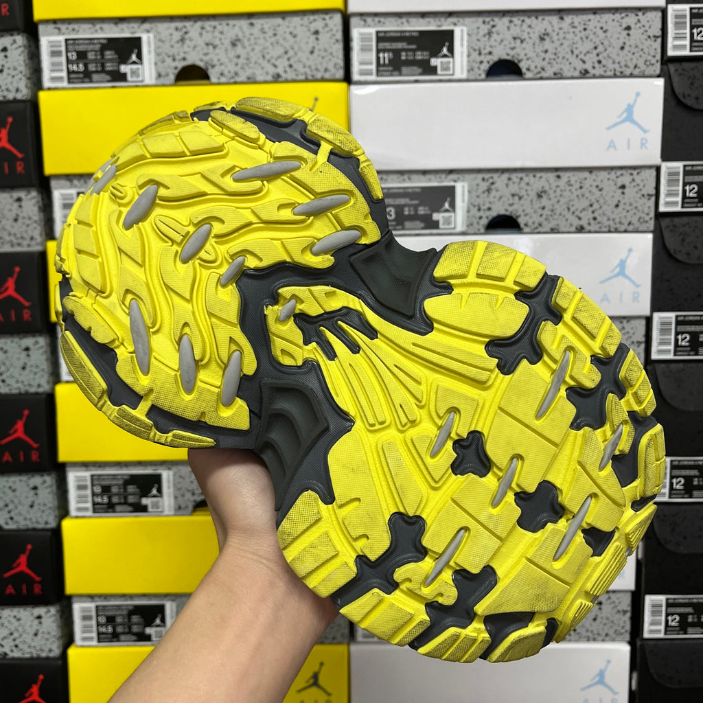 Outsole tread of neon yellow and dark gray sneaker with deep traction lugs.