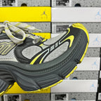Quarter view lace-up sneaker in dark gray with neon yellow accents and textured sole.