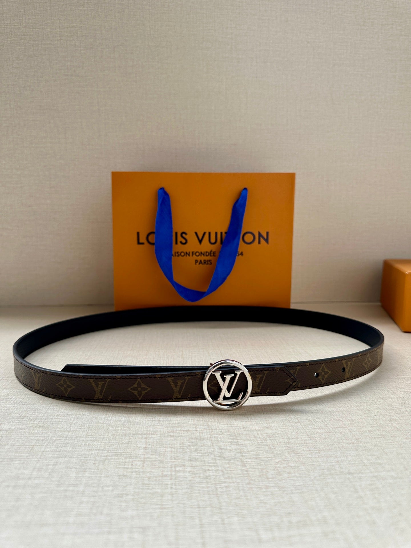 Louis Vuitton belt with dark monogram strap and round silver-tone logo buckle