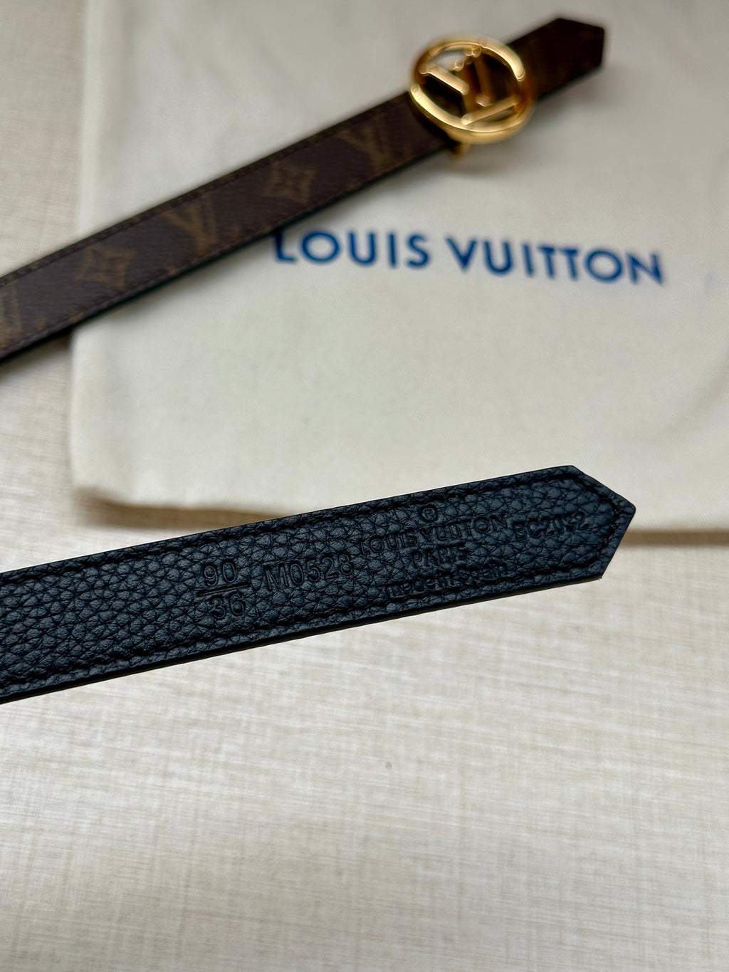Dark textured leather belt with gold-tone LV buckle and monogram strap end
