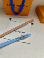 Tan leather belt strap with rivet holes, beside light blue gold LV buckle belt.