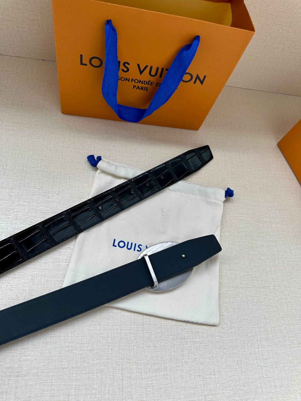 Louis Vuitton belt with dark blue leather strap and small rectangular buckle hardware