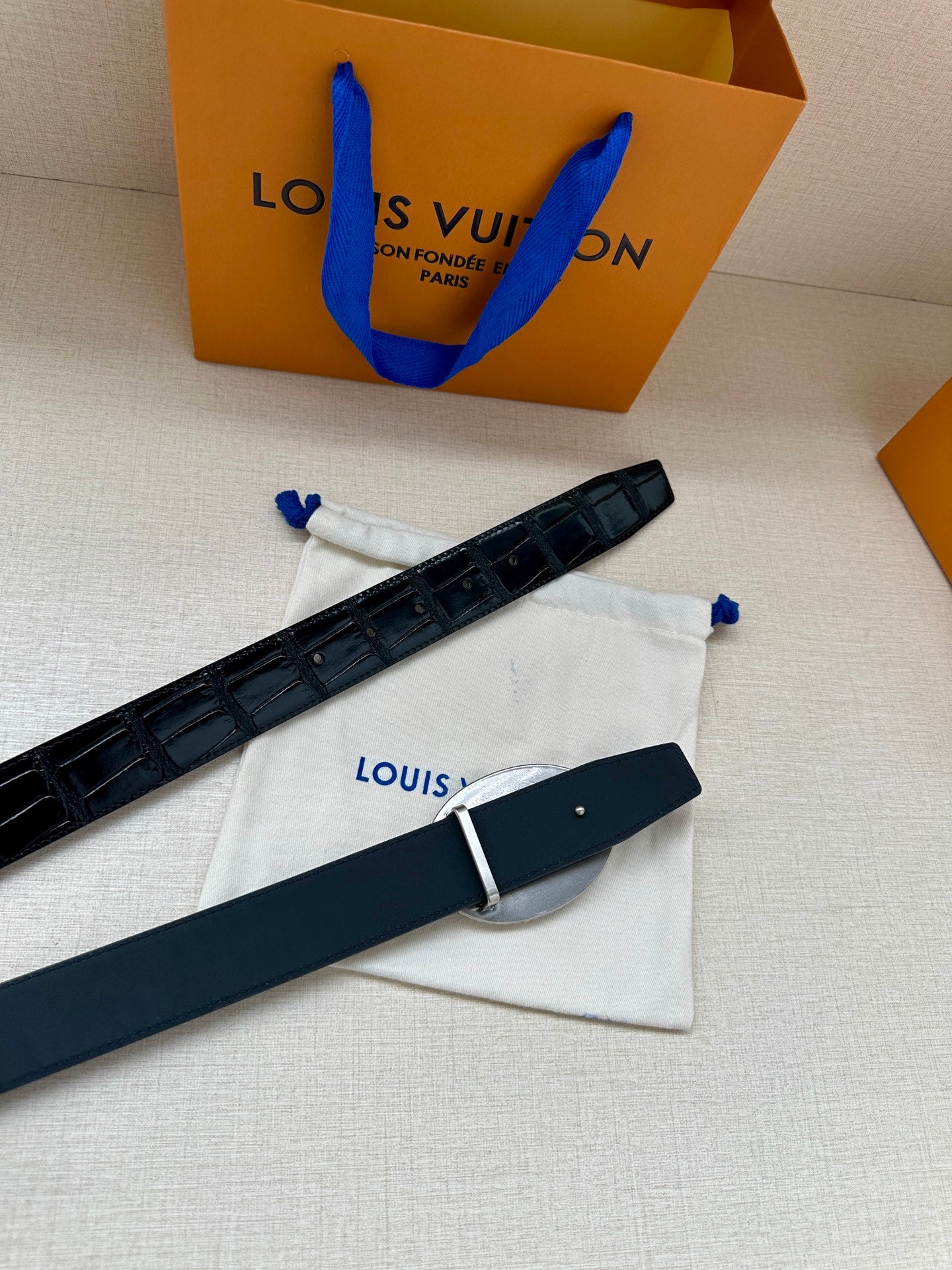 Louis Vuitton belt with dark blue leather strap and small rectangular buckle hardware