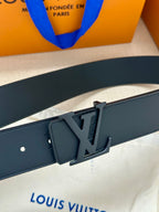 Louis Vuitton belt buckle close-up on dark leather strap with embossed logo