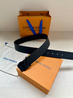 Louis Vuitton leather belt with dark buckle and strap holes, laid flat