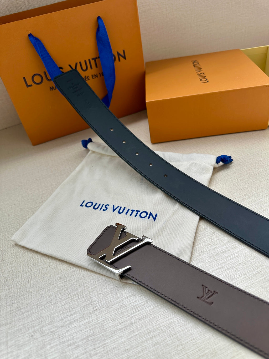 Louis Vuitton belt with dark strap, LV buckle, and engraved leather details