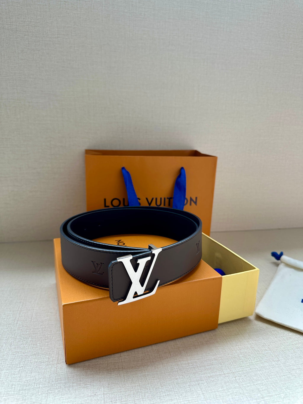 Louis Vuitton belt with dark leather strap and gold LV buckle on top