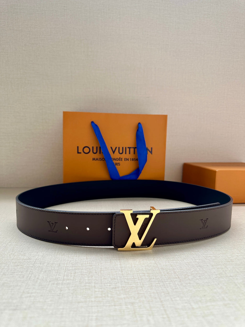 Louis Vuitton belt with dark leather strap and gold LV monogram buckle