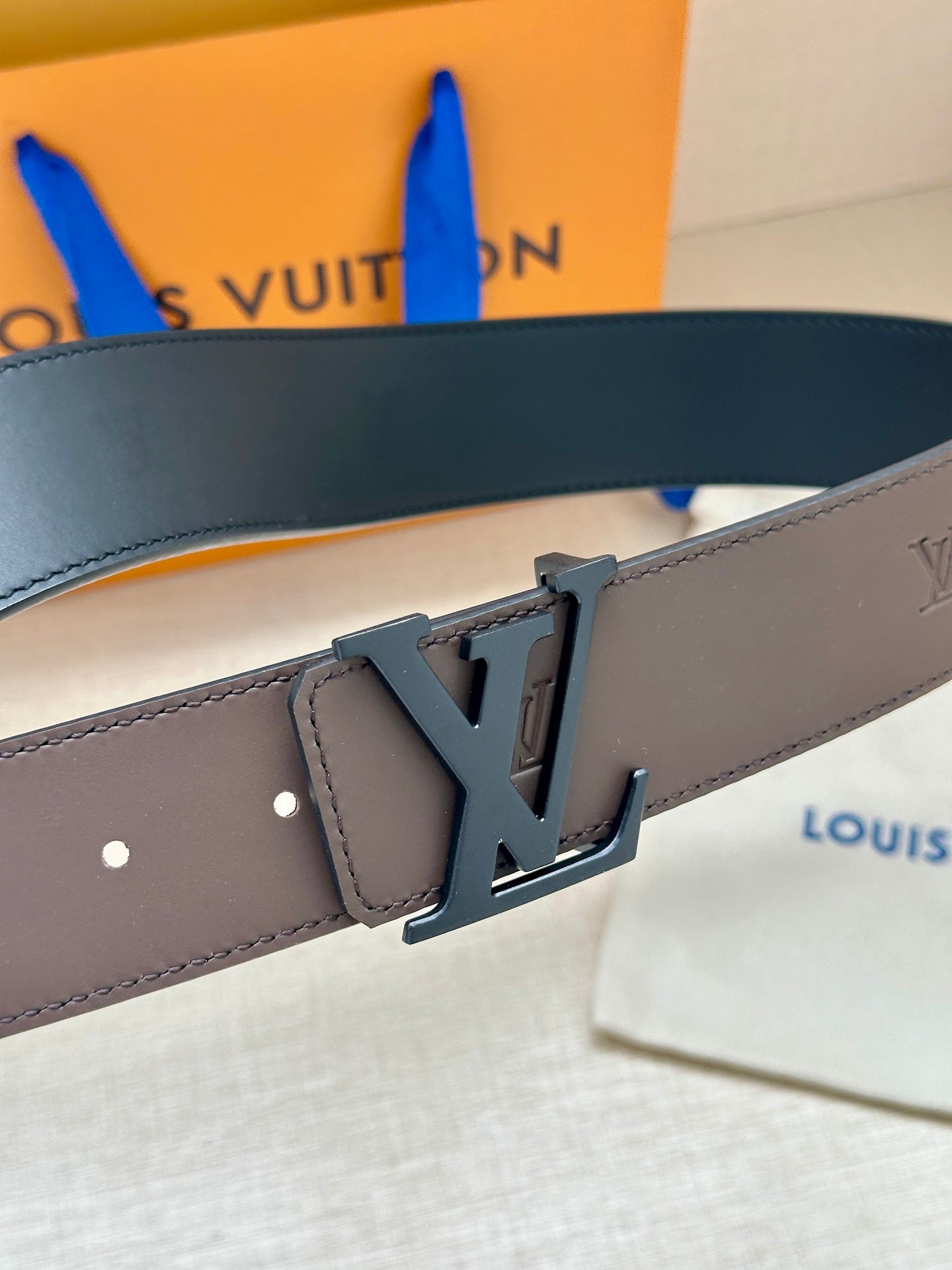 Louis Vuitton belt close-up: dark brown leather strap with LV buckle detail